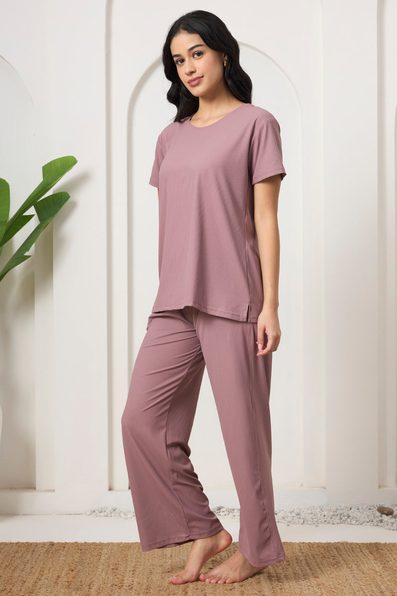 Woman in a mauve ribbed t-shirt and pyjama pants, side view