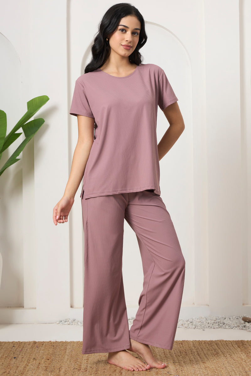 Woman standing in a mauve ribbed lounge set, front view