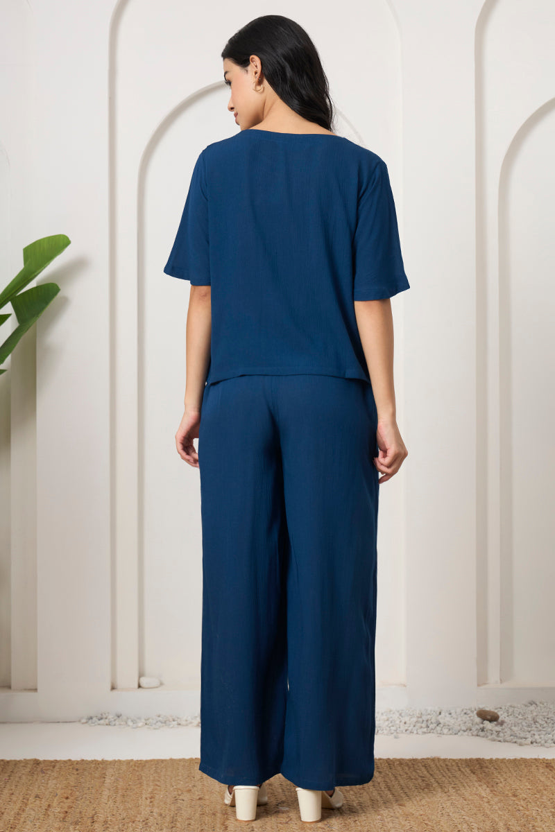 Back view of a woman wearing a teal crop top and wide leg pants