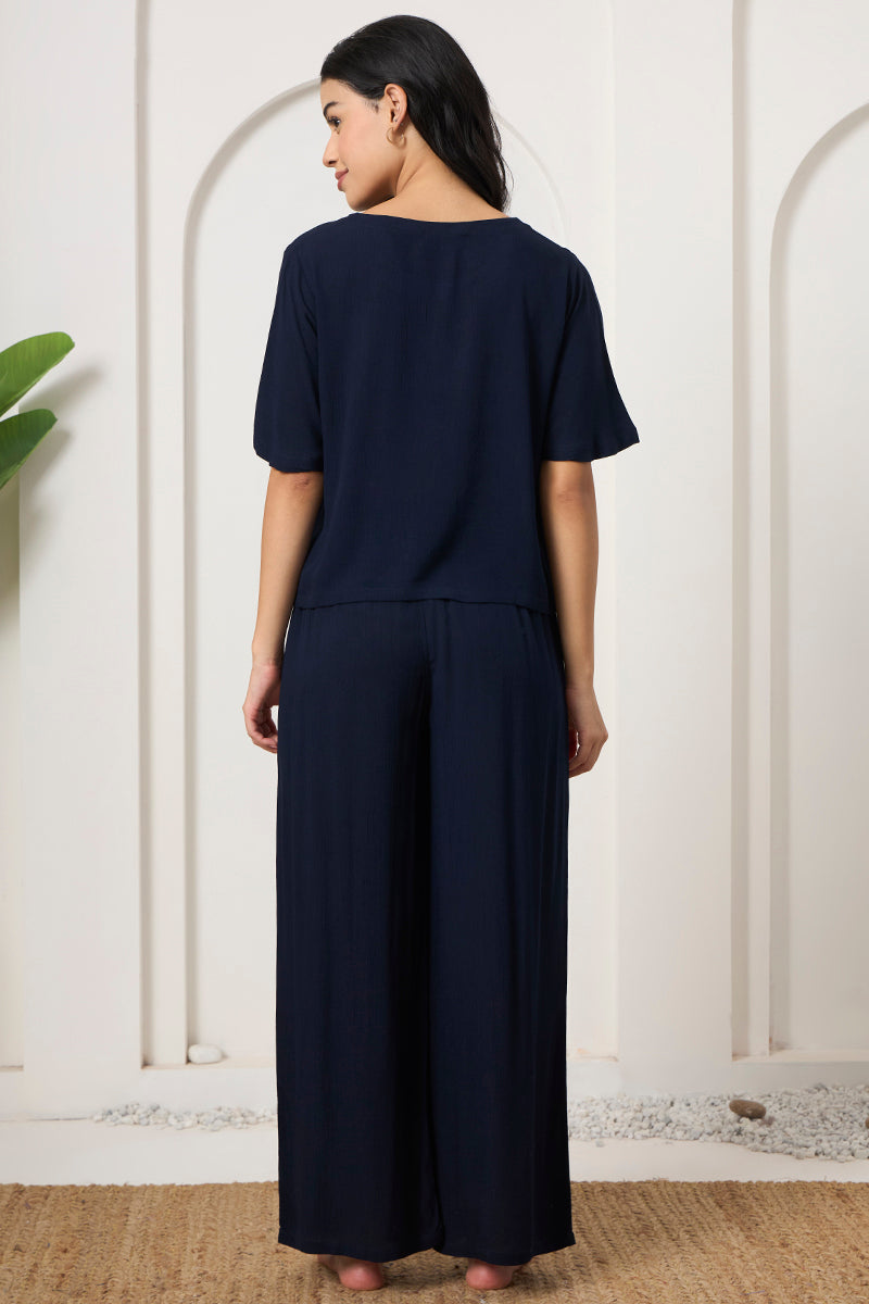 Back view of a woman wearing a navy crop top and wide leg pants