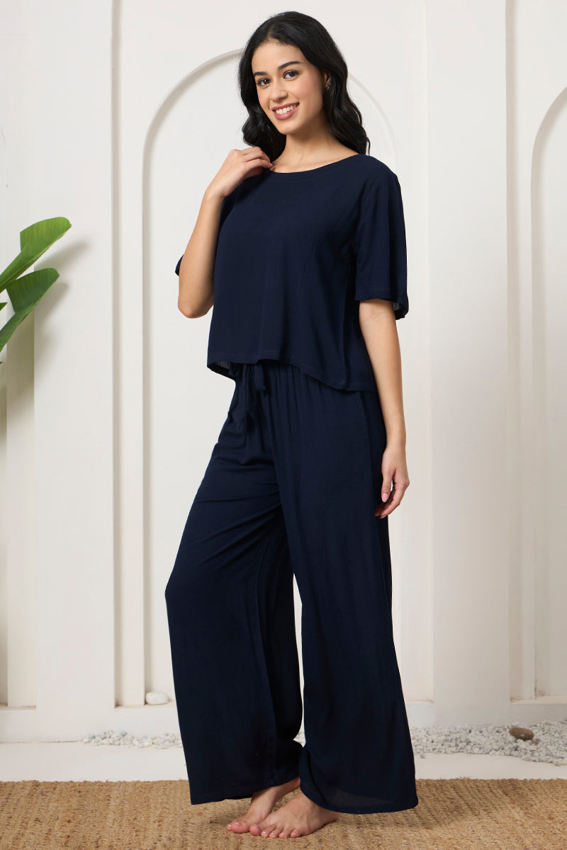 Smiling woman in a navy crop top and wide leg pants