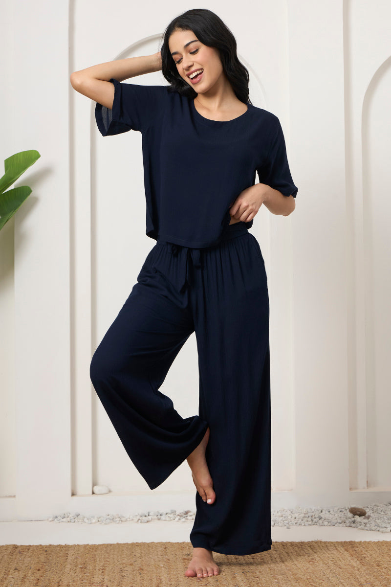 Woman posing in a navy crop top with flared wide leg pants