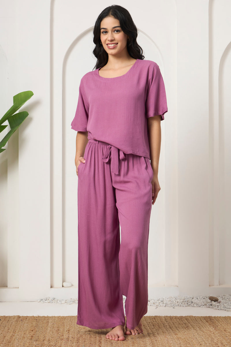 Woman smiling in a mauve crop top and wide leg tie waist pants