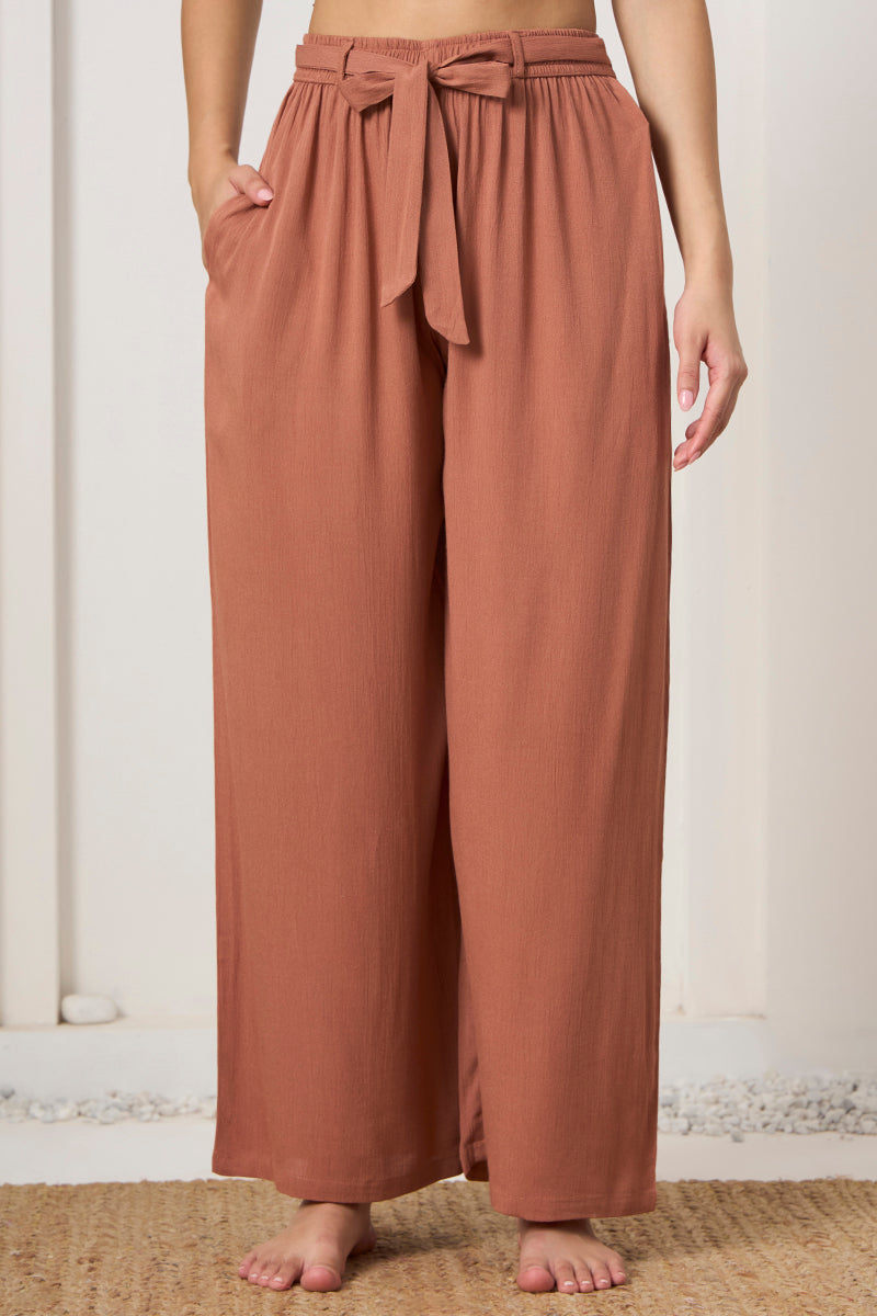 Close up of the tie waist and pocket detail on the rust wide leg pants