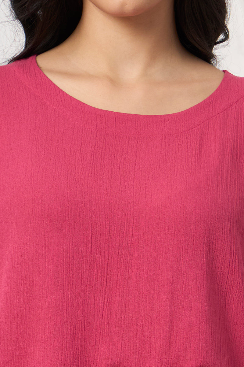 Close up of the round neckline and fabric texture on the pink top