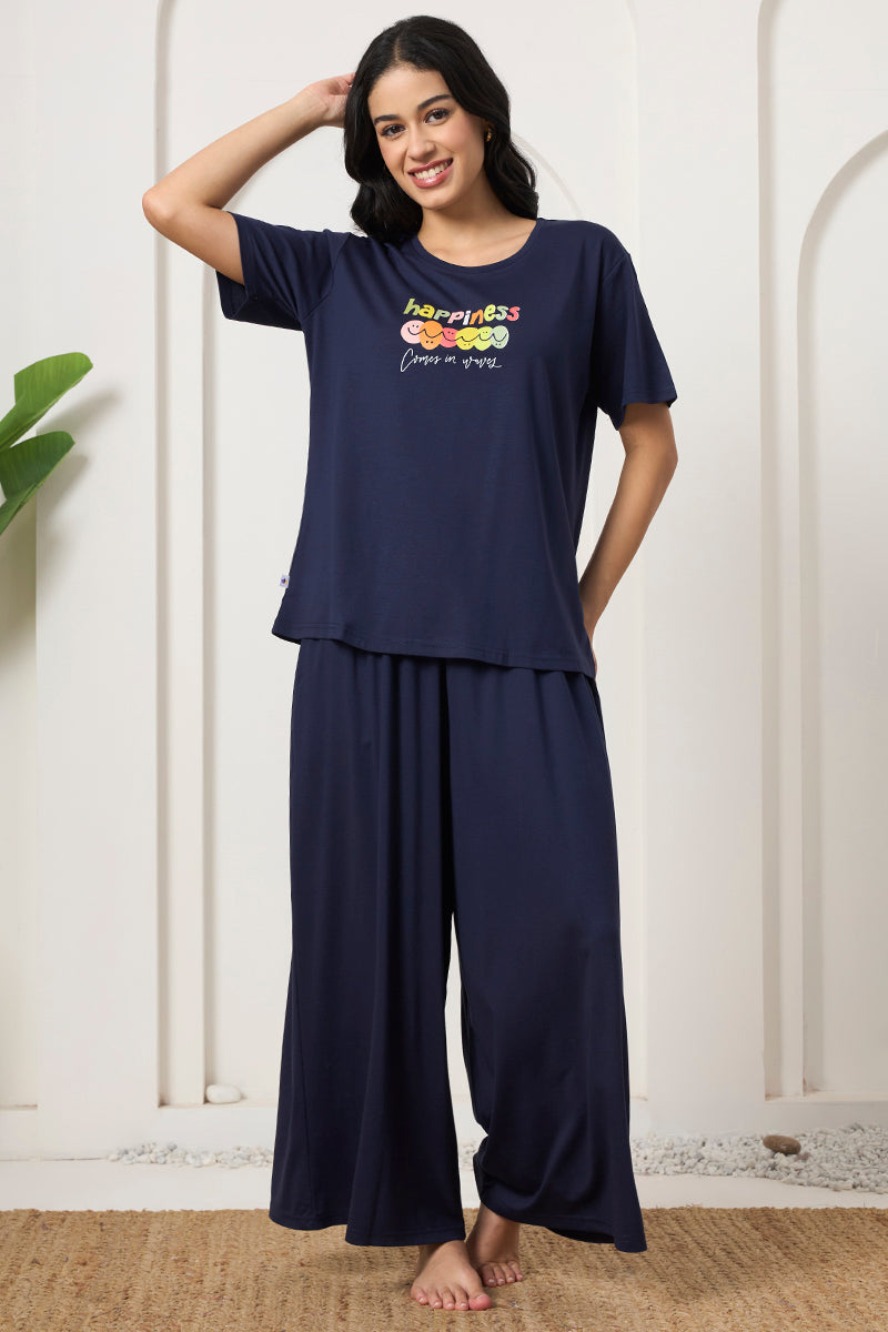 Woman standing in a navy t-shirt and wide leg pants co-ord set