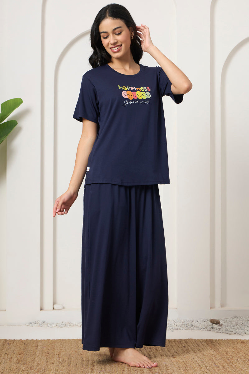 Woman smiling with hand in hair wearing a navy t-shirt and pants set