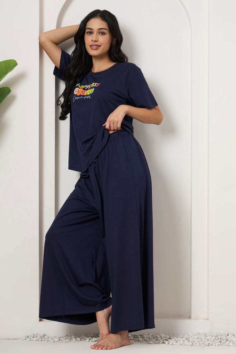 Woman leaning against a wall in a navy loungewear set