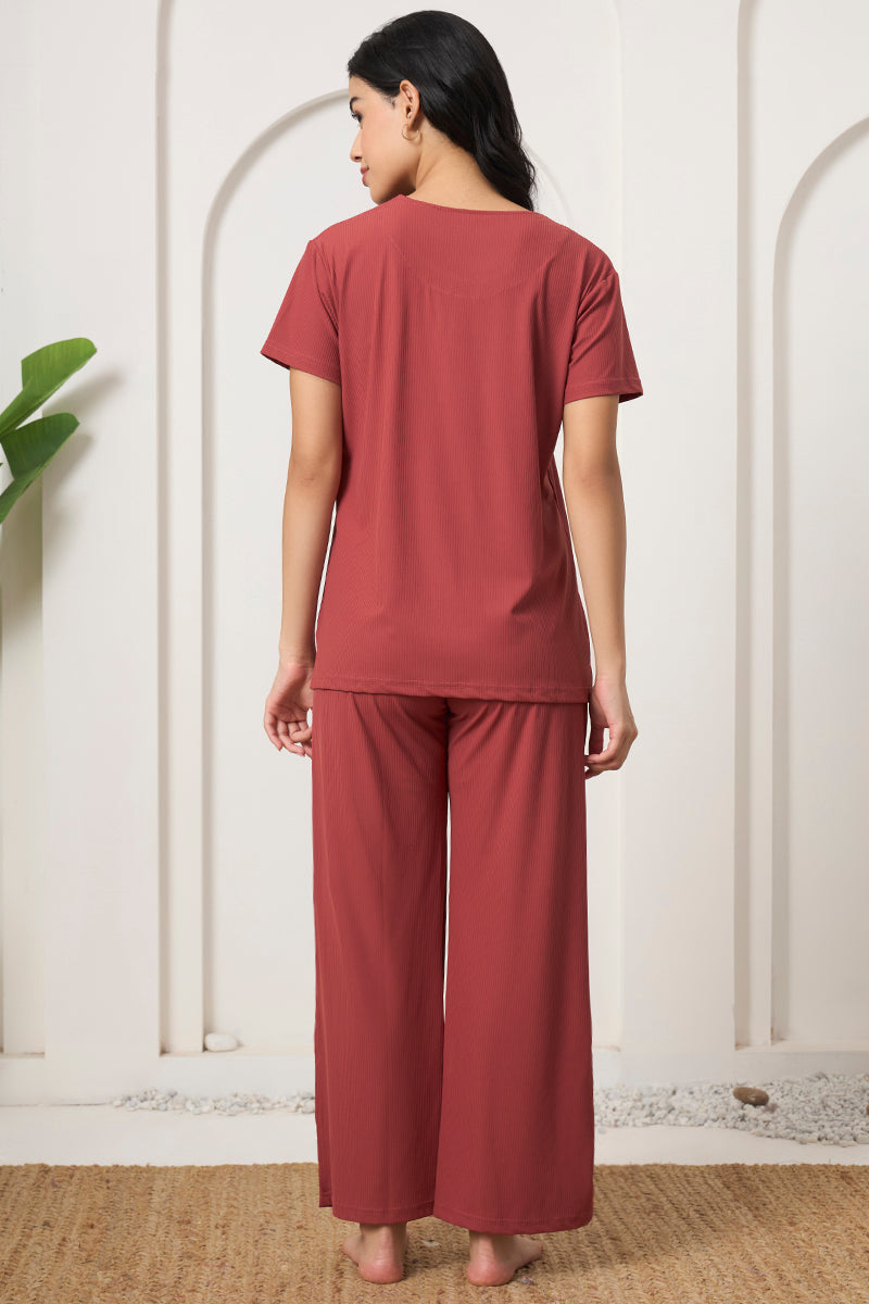 Back view of a woman wearing a rust ribbed pyjama set