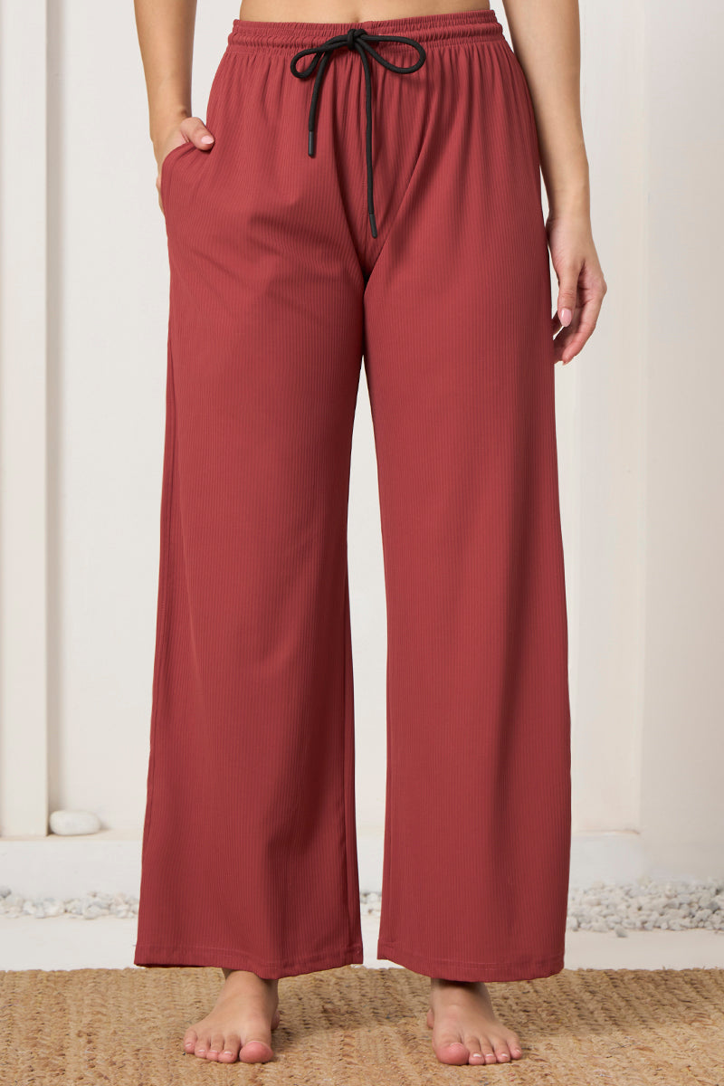 Close up of drawstring waistband on rust ribbed pyjama pants