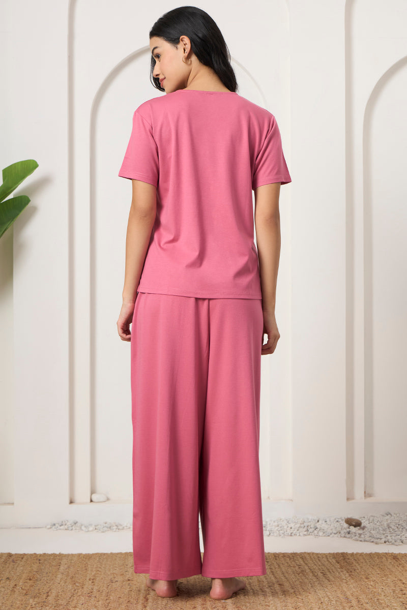 Back view of a woman wearing a pink t-shirt and wide leg pants set