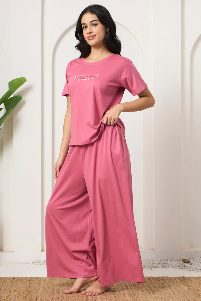 Woman standing with hand on waist wearing a pink loungewear set