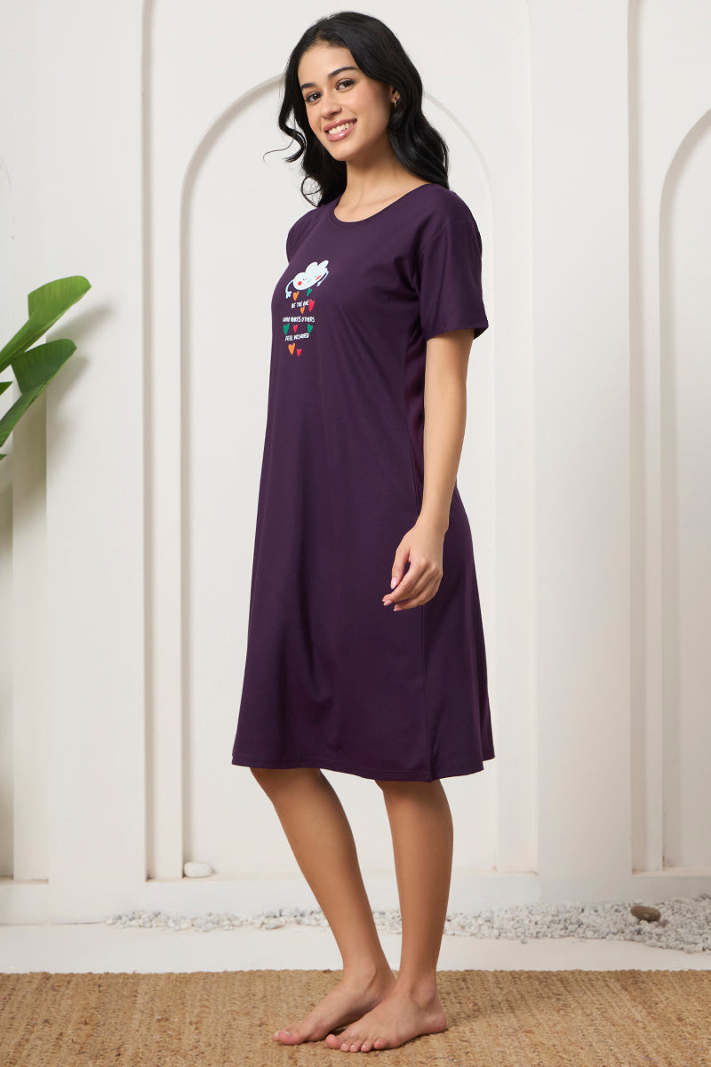 Woman standing sideways smiling in a purple round neck nightdress