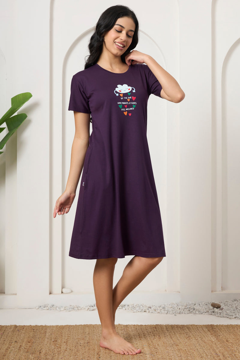 Woman posing with hand near shoulder in a purple short sleeve nightdress