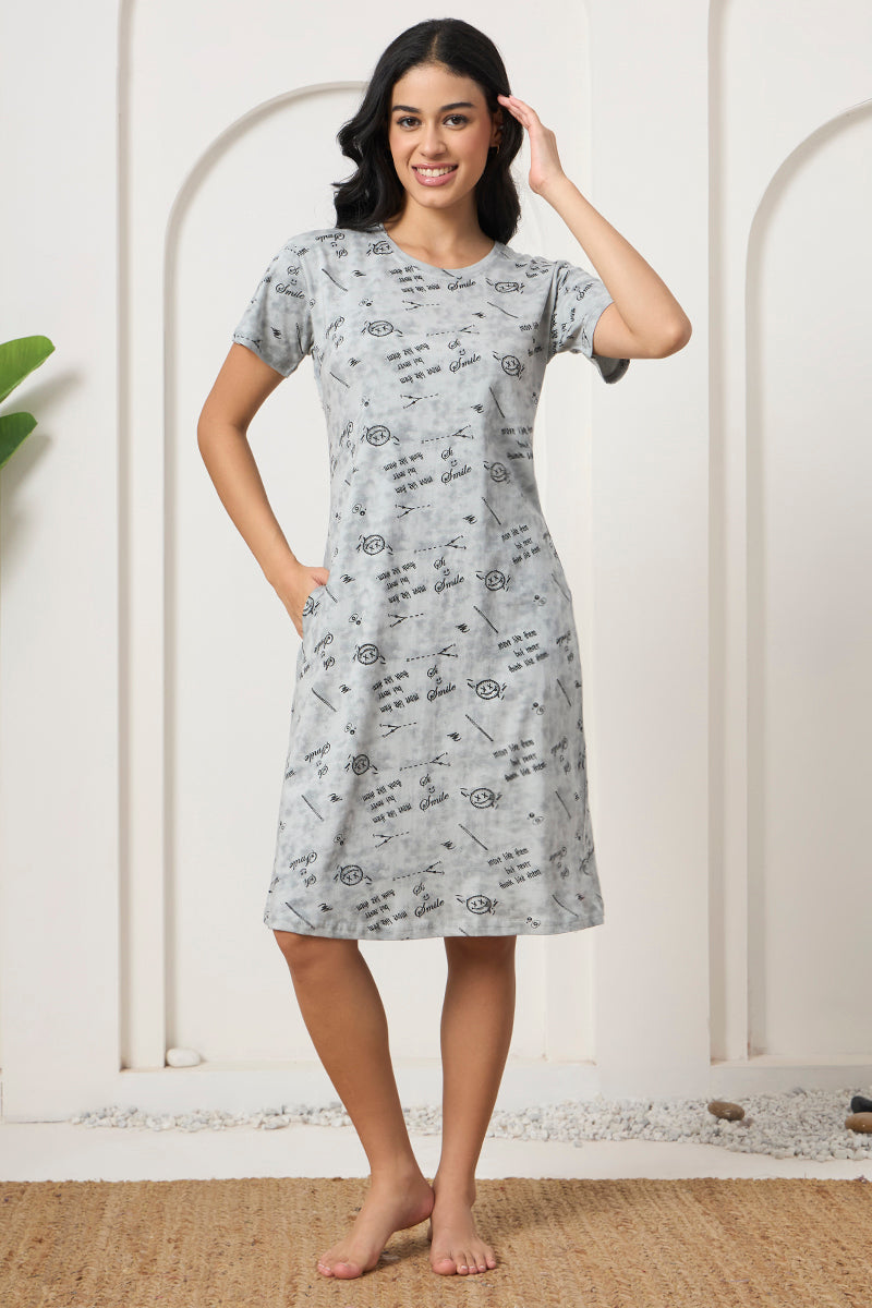 Woman standing in a grey printed nightdress with pockets