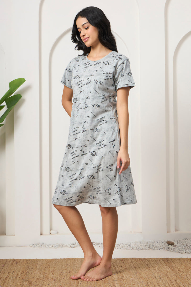 Woman standing sideways smiling in a grey printed nightdress