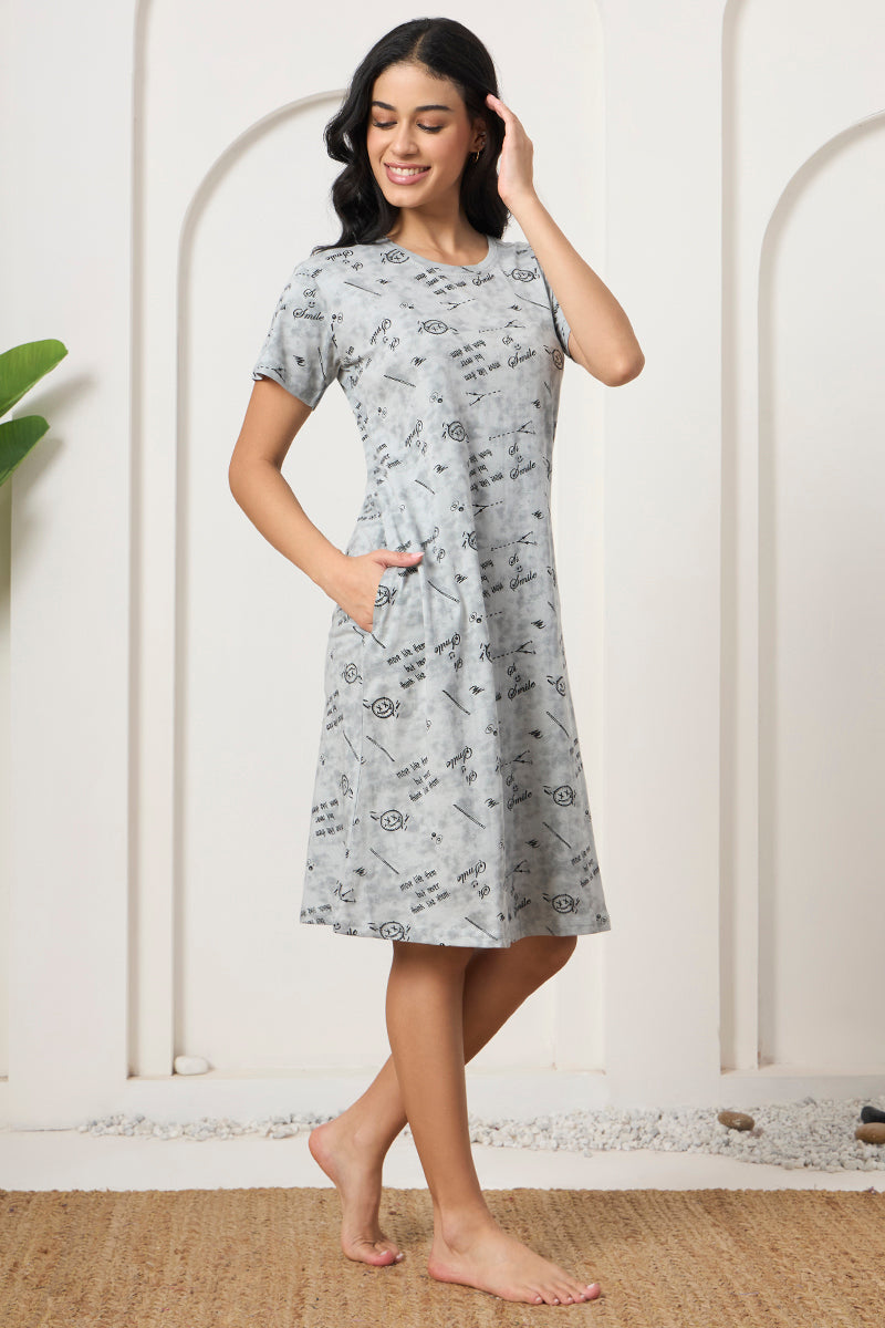 Woman smiling sideways in a grey printed short sleeve nightdress