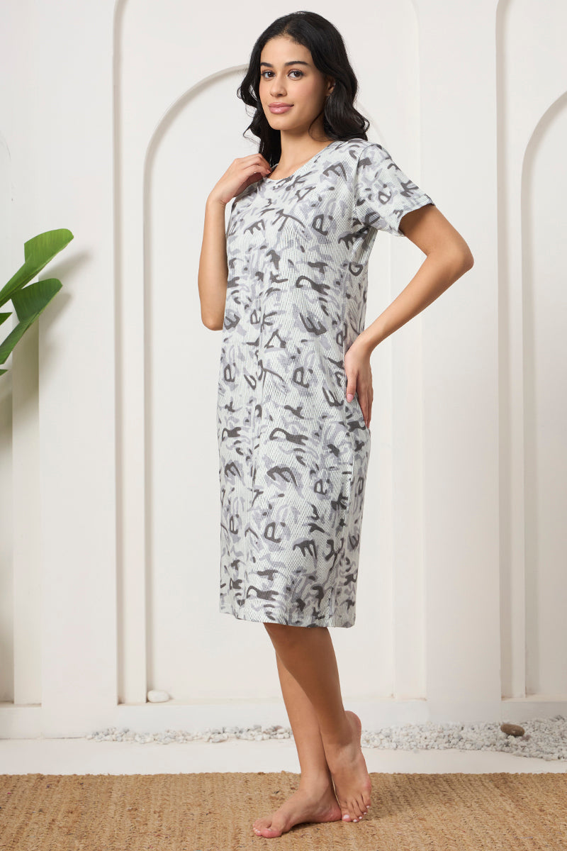 Woman standing with hand on hip in a grey abstract print nightdress