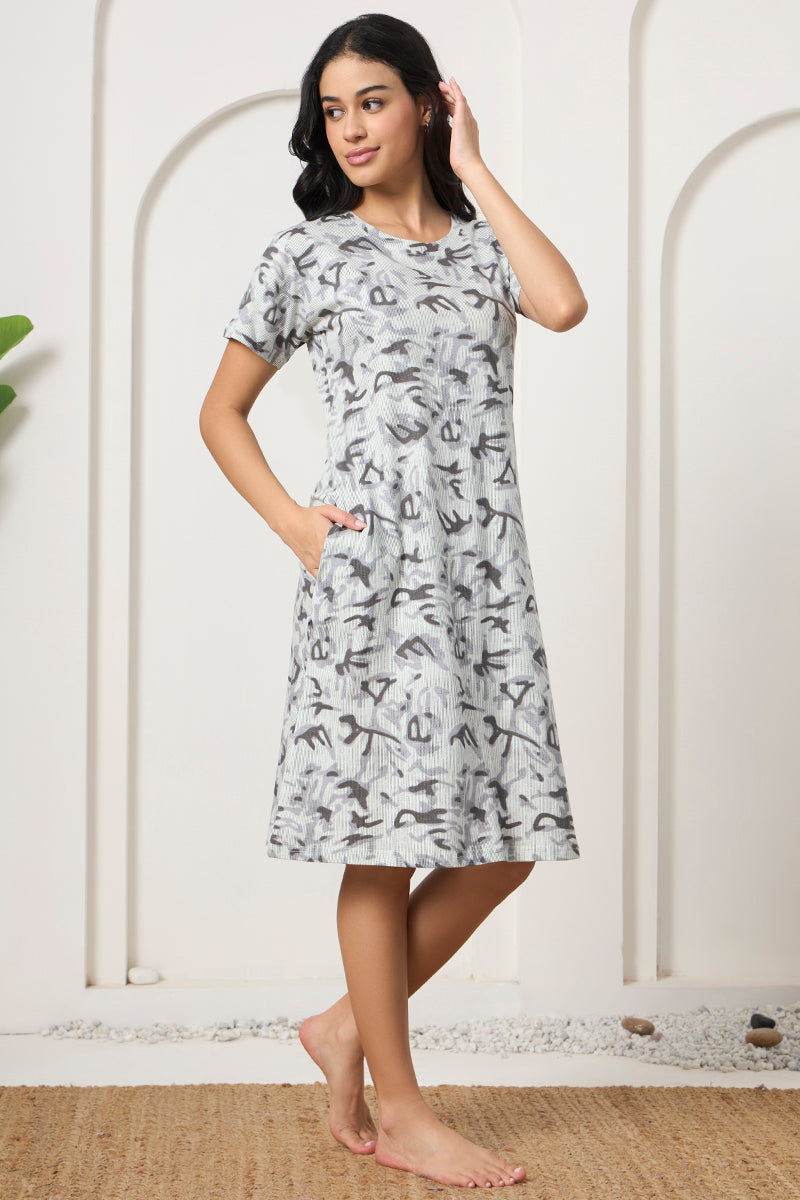 Woman posing sideways in a grey abstract print nightdress