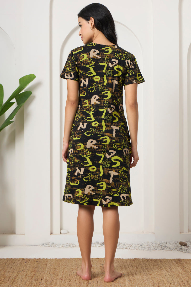 Back view of a woman wearing a black and green typographic print nightdress