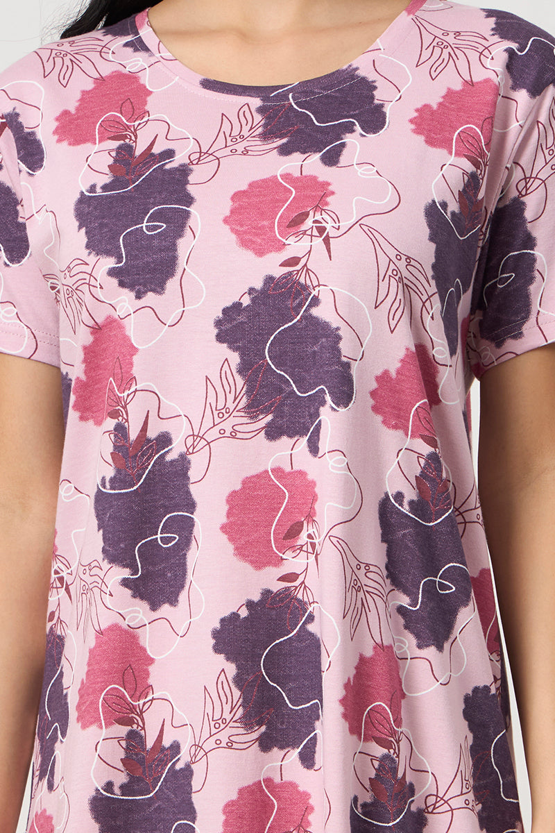 Close up of the round neckline and floral print detail on the pink nightdress