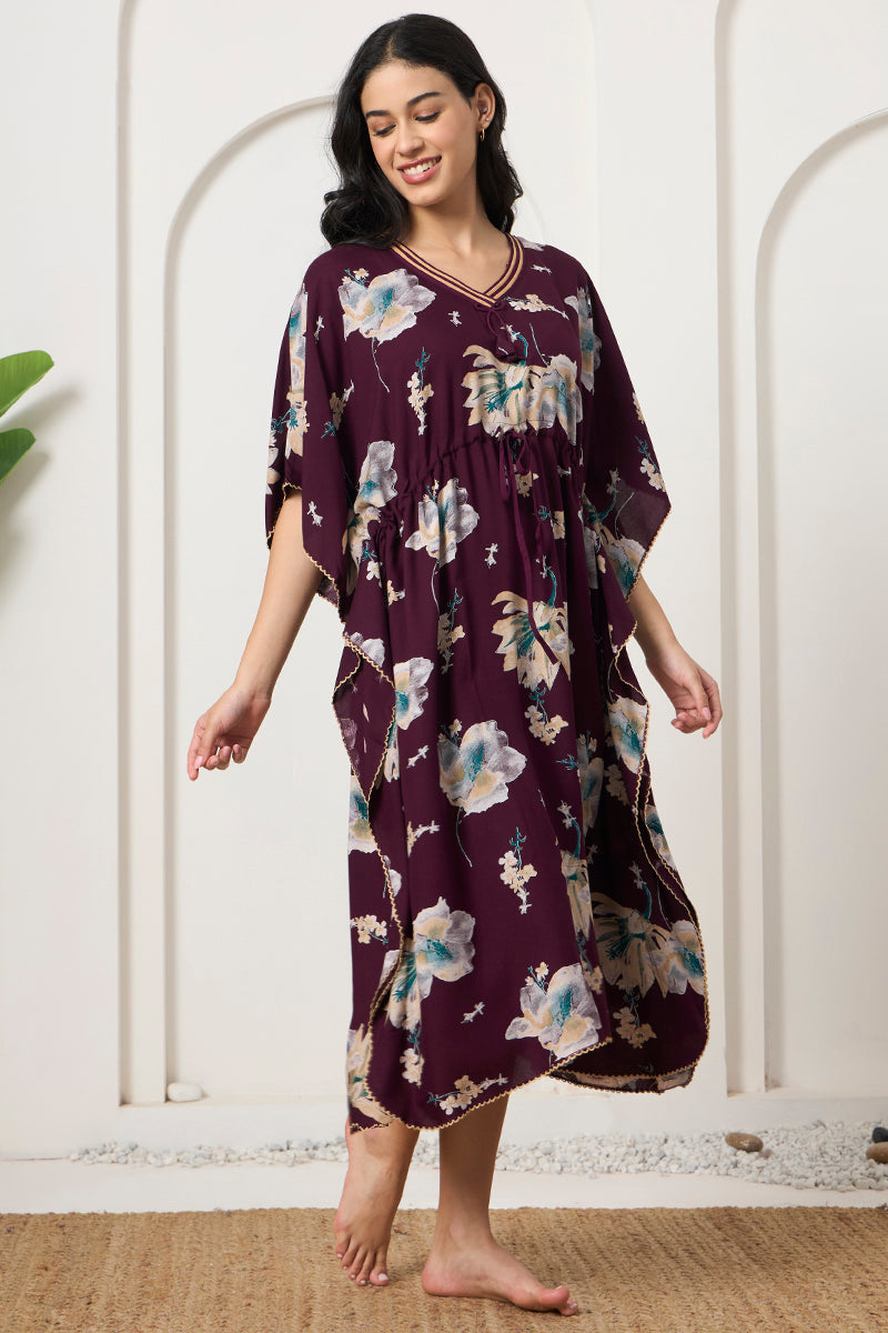 Woman posing in a wine floral kaftan with tie neck detail