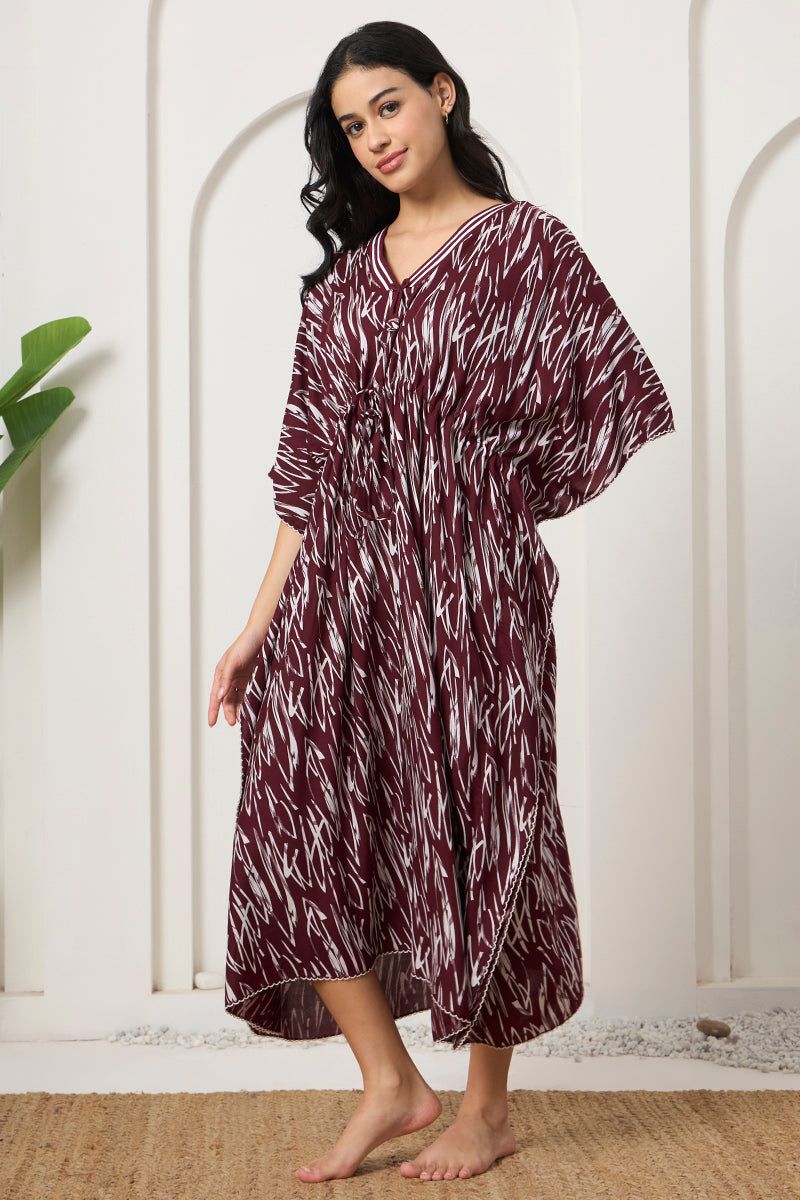 Woman posing sideways in a wine abstract print kaftan