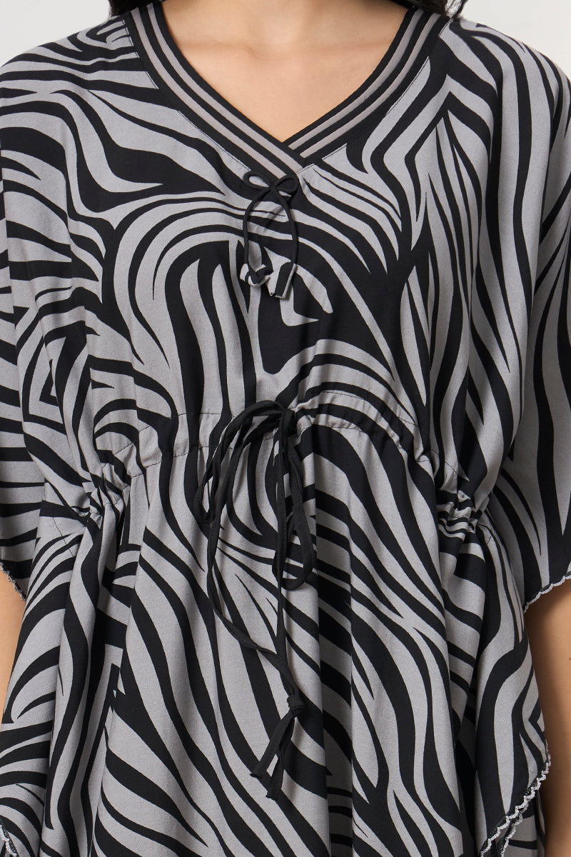 Close up of the tie neck and drawstring detail on the zebra print kaftan