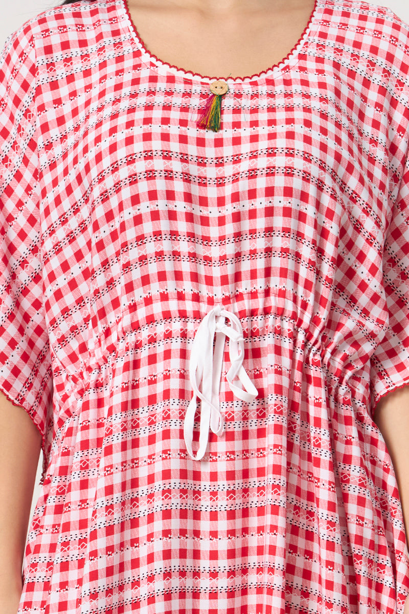 Close up of the tassel button and drawstring waist on the red check kaftan