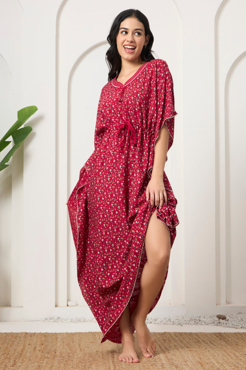 Woman laughing in a red floral kaftan with front slit detail