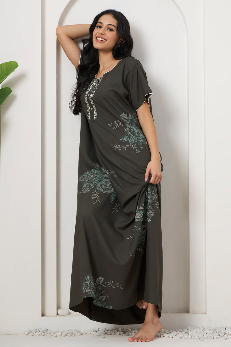 Woman smiling with hand in hair, wearing a floral print maxi nightgown