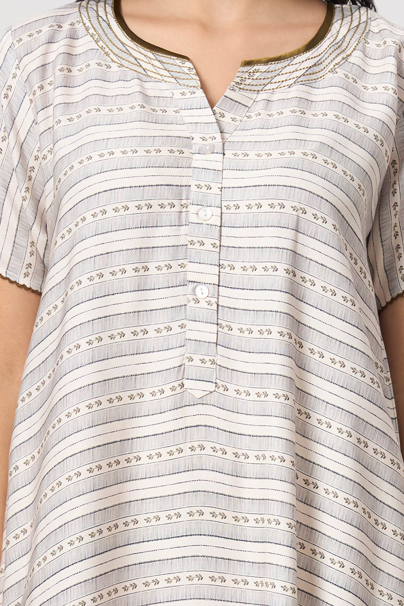 Close up of the button placket and embroidered neckline on the beige nightgown