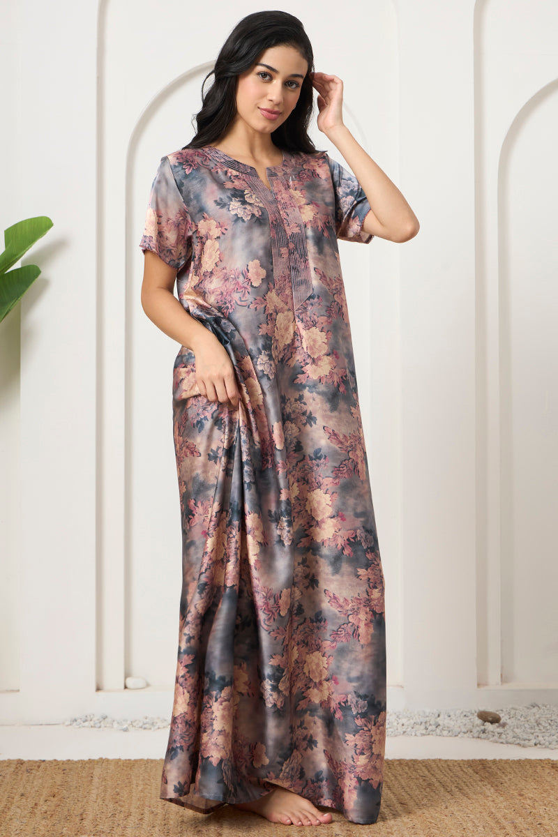 Woman standing with hand in hair, wearing a grey floral nightgown